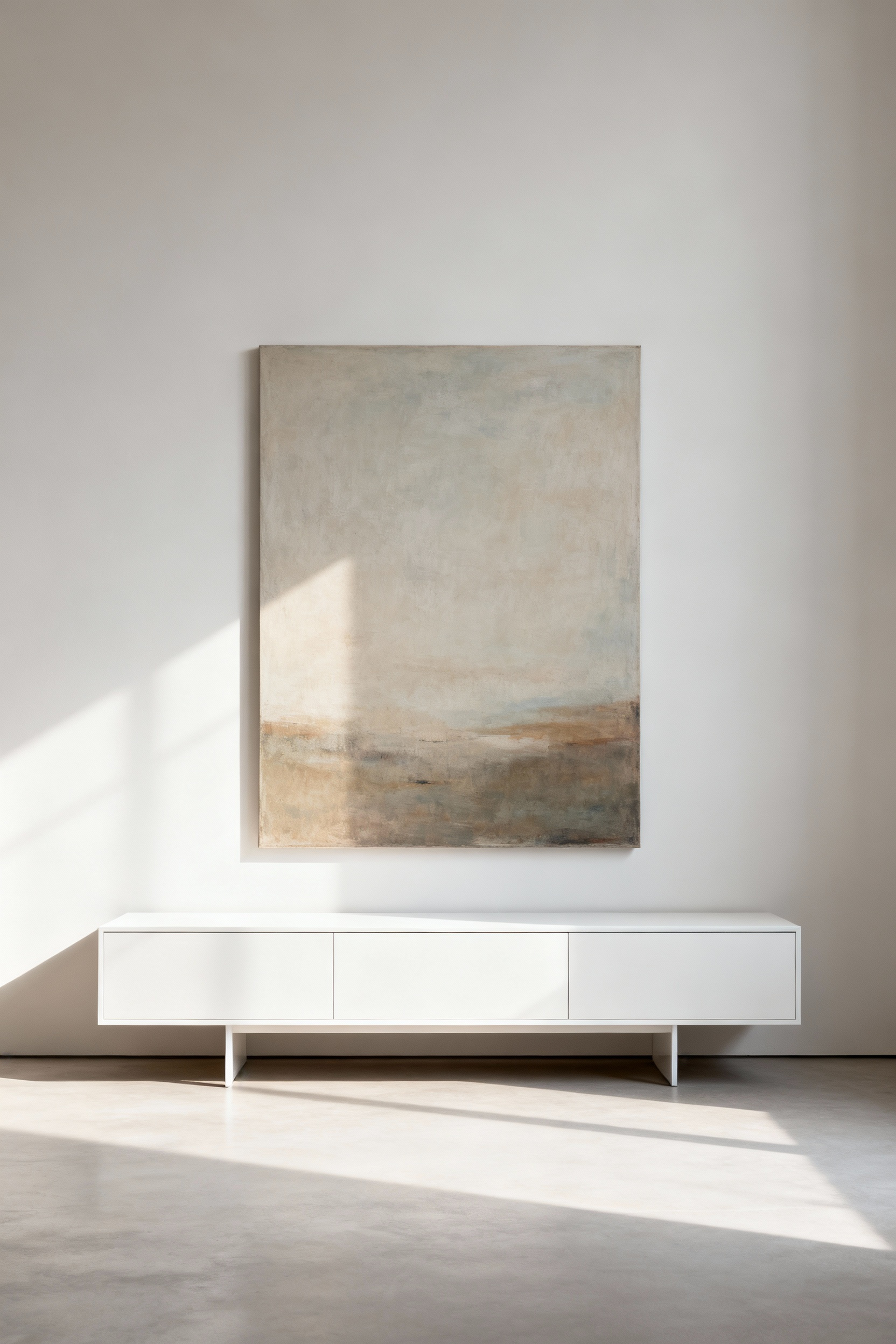 Minimalist kitchen with a large abstract art print framed by ample negative space above a floating credenza, highlighting sophisticated design.
