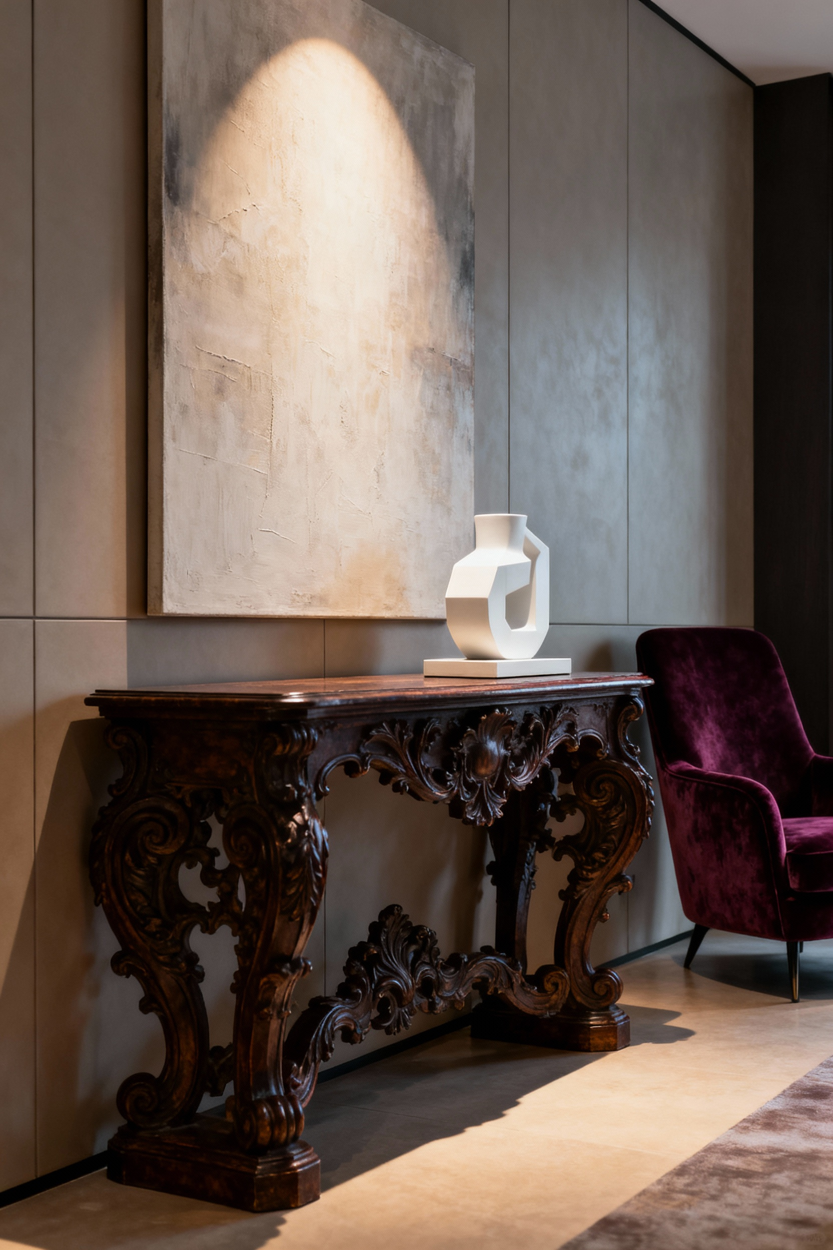An elegant living room interior featuring a dark wood classical console table juxtaposed with a minimalist white ceramic sculpture, underneath an abstract art piece and beside a modern velvet armchair. The space is illuminated by warm ambient and accent lighting.